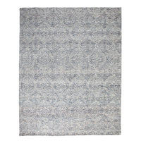 The Dreamtime Hand Tufted Wool Grey Rug 300x240cm features a subtle, symmetrical geometric pattern in gray and blue tones, making it perfect for adding a touch of contemporary style to any room.
