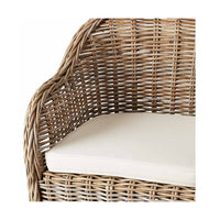 Close-up of the Martinique Rattan Armchair, showcasing its woven design with an off-white cushion that exudes European elegance and tropical beauty.