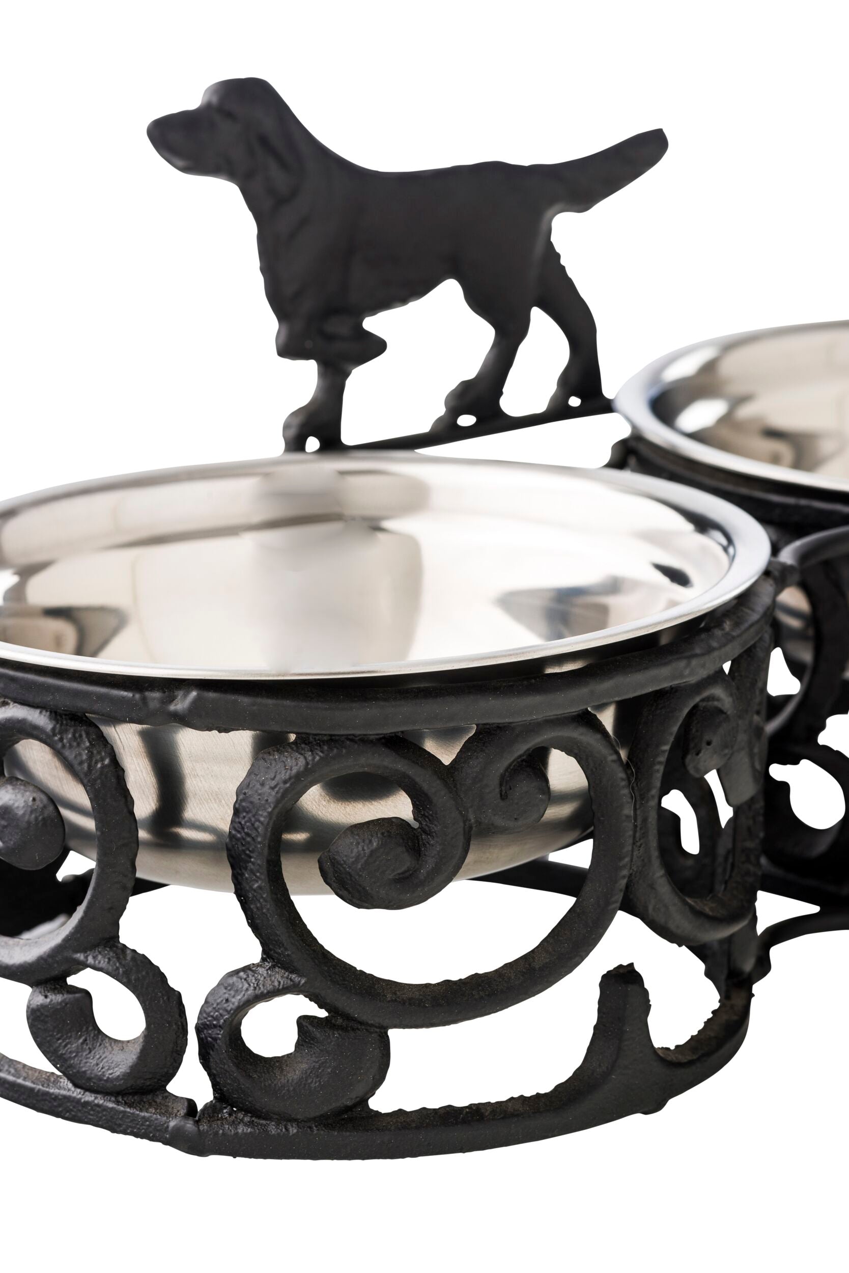 The Double Dog Bowl 35x17cm is an antique black and silver stand, crafted from durable wrought iron, adorned with a charming dog silhouette on top, and includes two stainless steel bowls for added convenience.