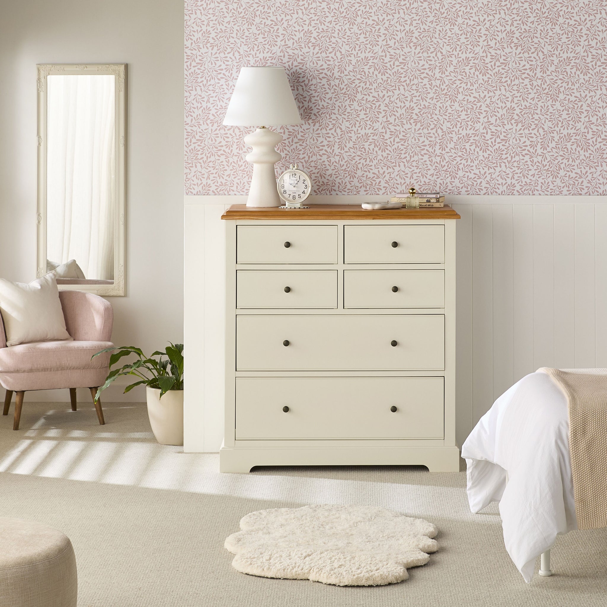 Close-up of a drawer being opened on a white dresser showing storage space.
