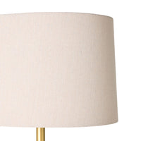Close-up of the Siena Round Travertine Floor Lamp 155cm, featuring a beige fabric shade and gold metal base, photographed against a plain white background.