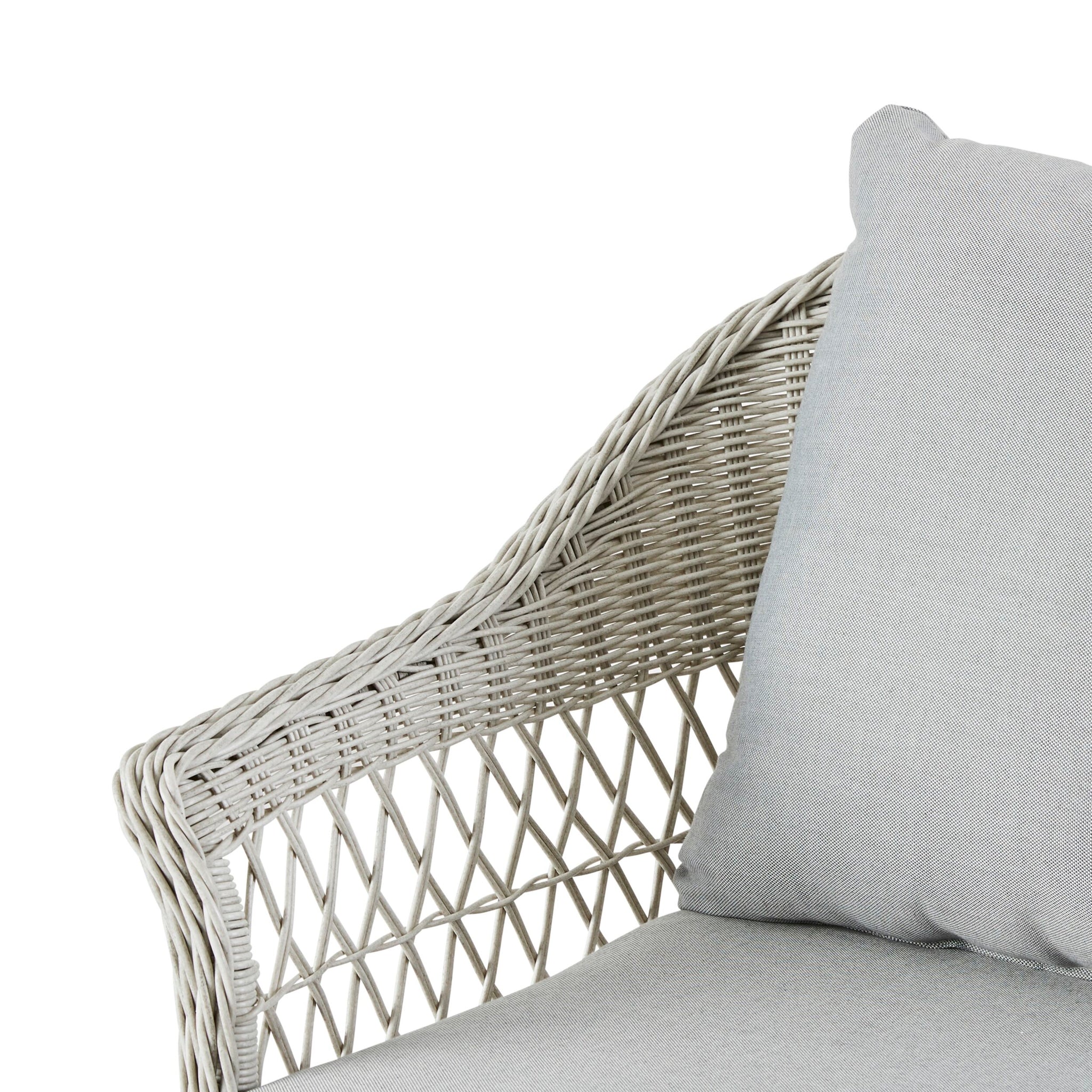 Close-up of a light gray wicker chair from the Catalina 4 Pce Sofa Set, featuring moisture-resistant cushions and a woven armrest design against a white background, ideal for an all-weather outdoor setting.