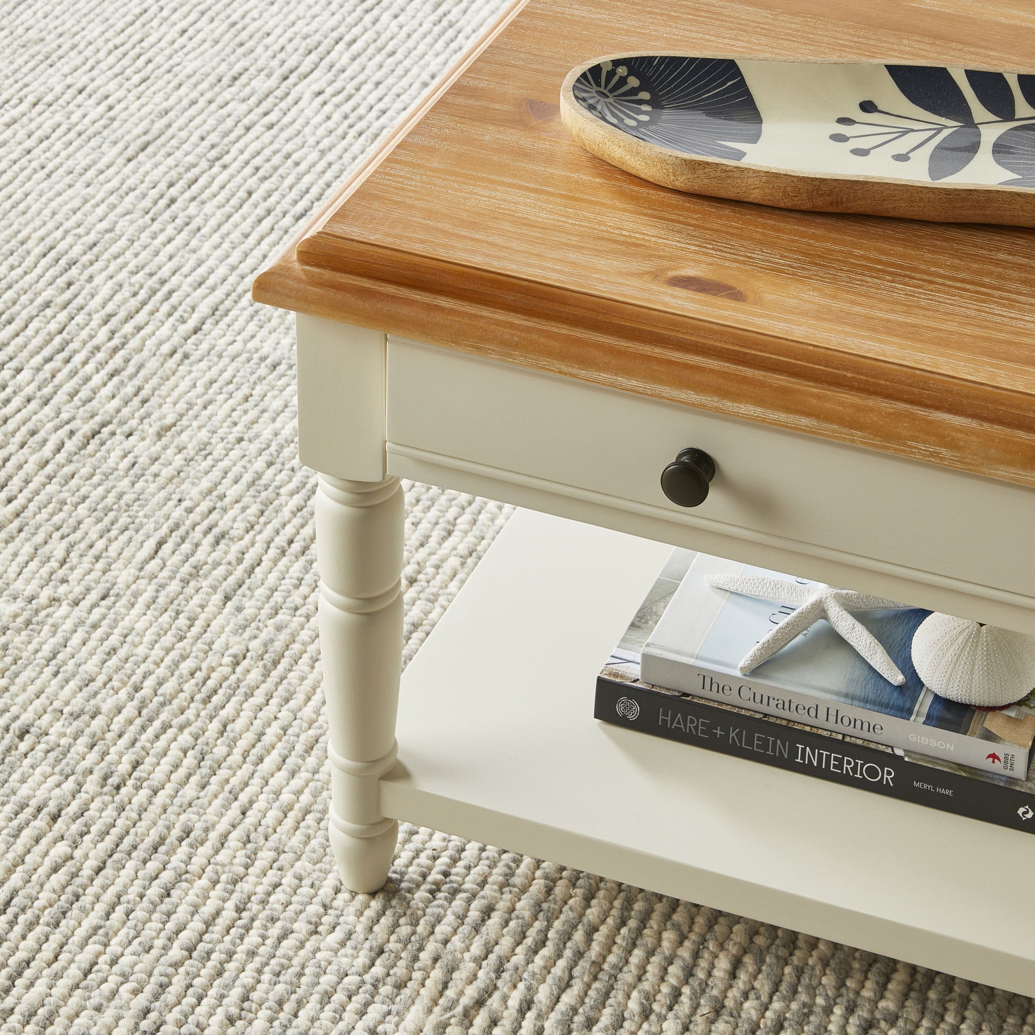 White and wood coffee table with two-drawer top and lower shelf, product isolated on white background.