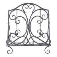 The Tissue/Book Stand 31x22x35cm features a decorative wrought iron design with scrollwork and chain weights on a flat base, offering vintage elegance and timeless charm.