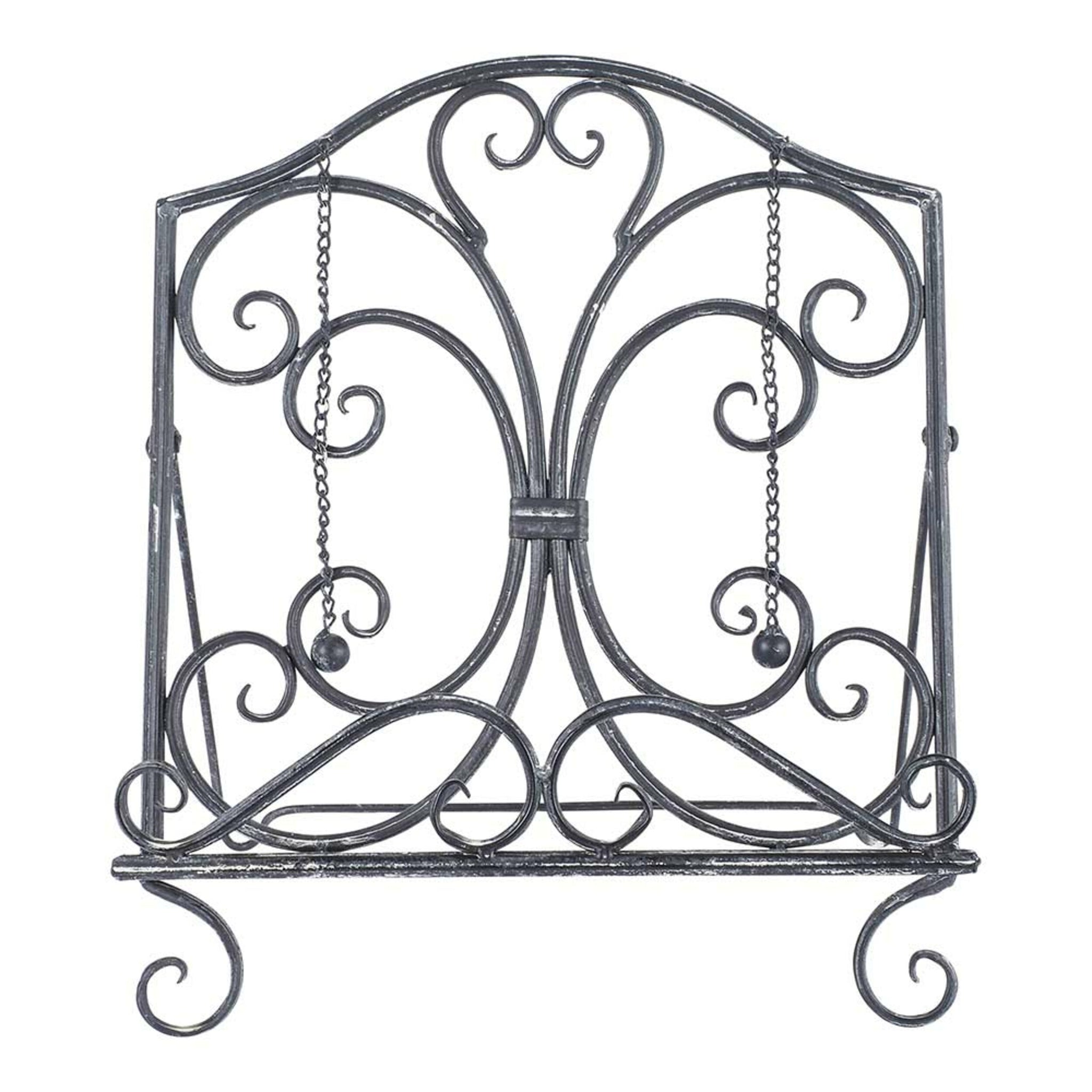 The Tissue/Book Stand 31x22x35cm features a decorative wrought iron design with scrollwork and chain weights on a flat base, offering vintage elegance and timeless charm.