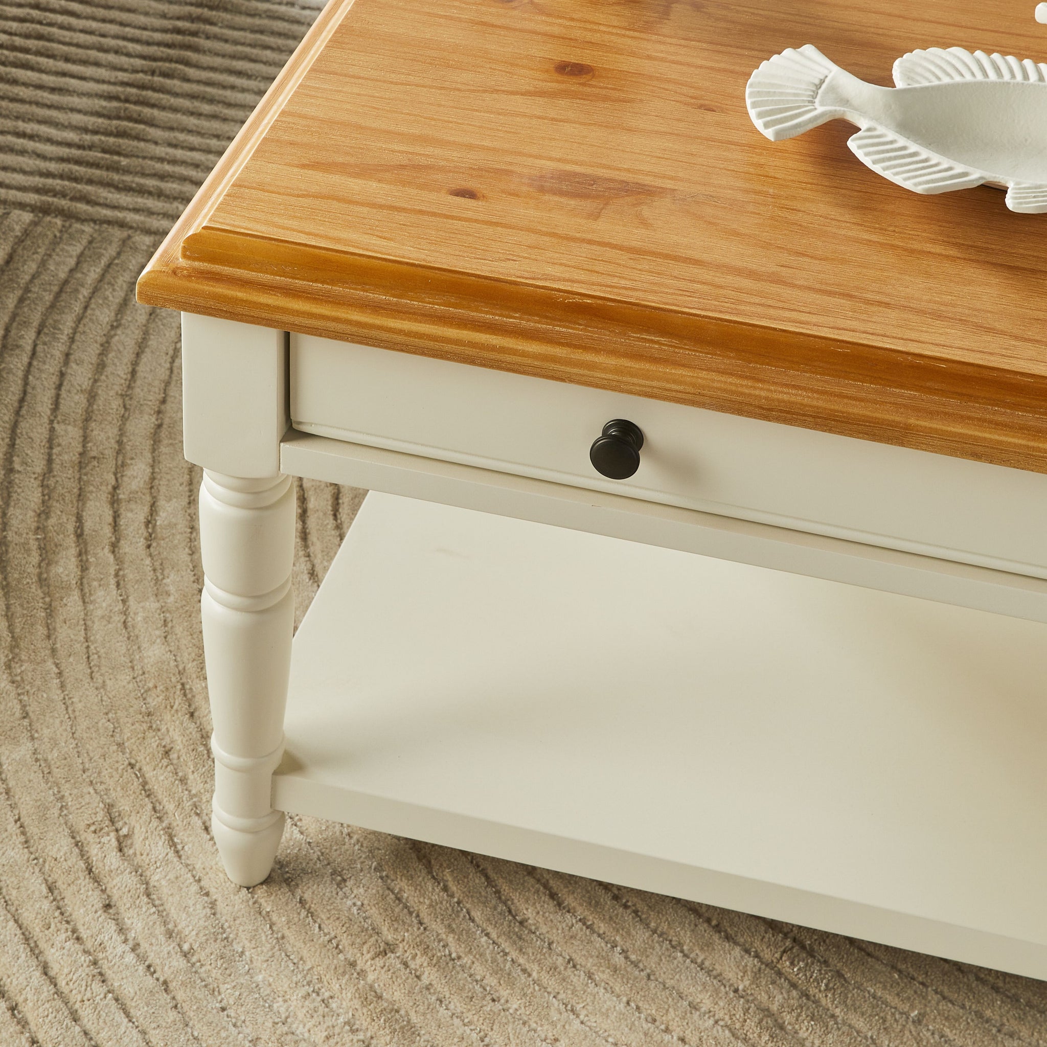 Full white and wood coffee table in a room setting with sofa and decor items.