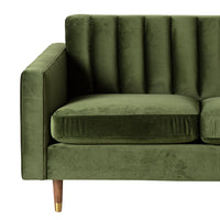 Stitch 2 Seater Velvet Sofa Juniper Olive shown from a front-side angle on a white background, featuring green velvet upholstery, vertical tufted backrest, wooden legs with brass caps, and gold metal foot detail.