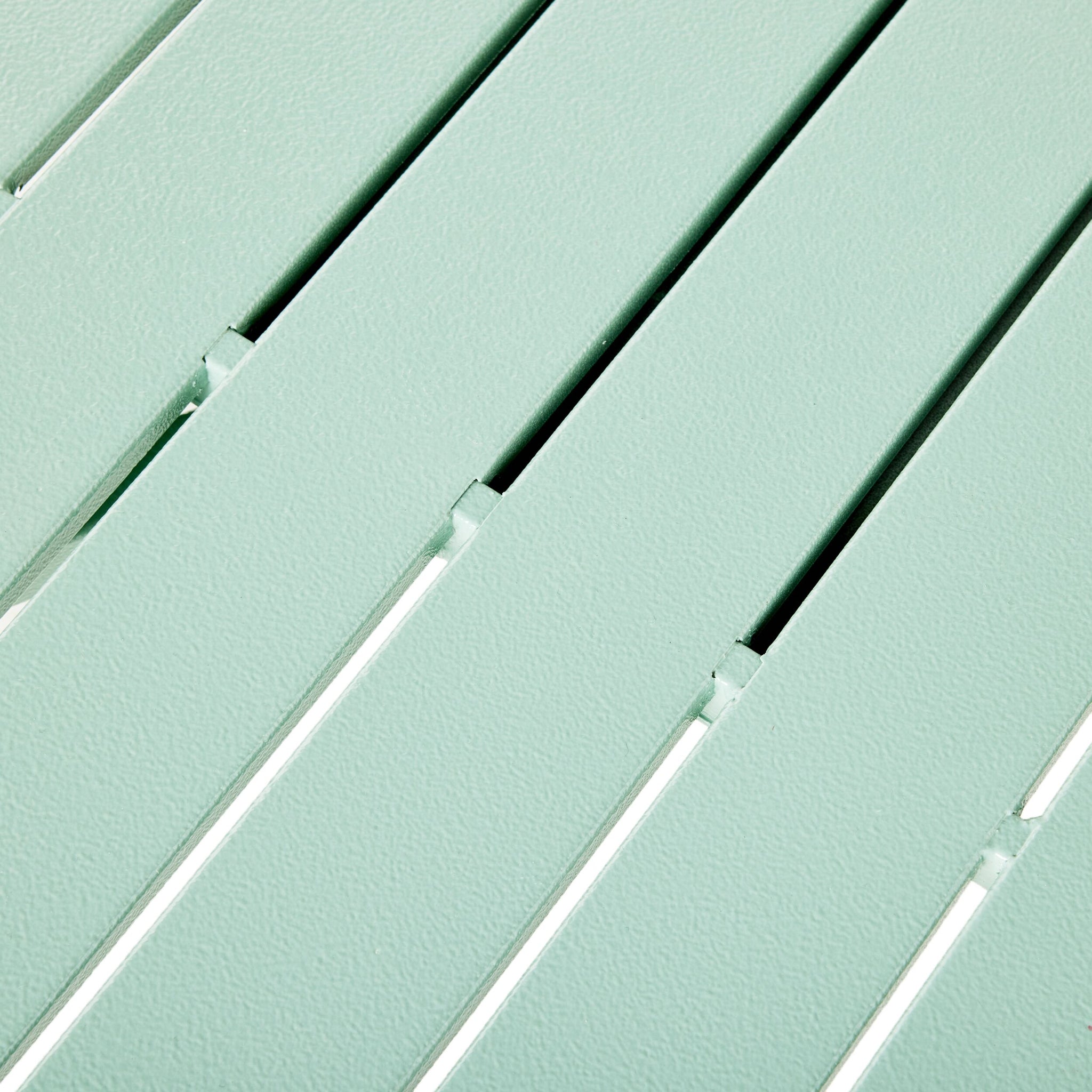 Close-up of the Kace Outdoor Coffee Table in Smoke Green, featuring a metal surface with evenly spaced slats and a textured finish.