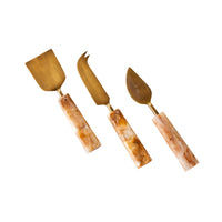 The Poppi Cheese Knives Set of 3 Tortoiseshell features brass blades and marbled resin handles with a tortoiseshell-inspired design, elegantly displayed against a white background.