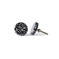 The Speckle Black and White Knob 4.4cm earrings feature a round design with a black base and white speckled terrazzo-like pattern; one earring is flat, the other upright to display the metal post.