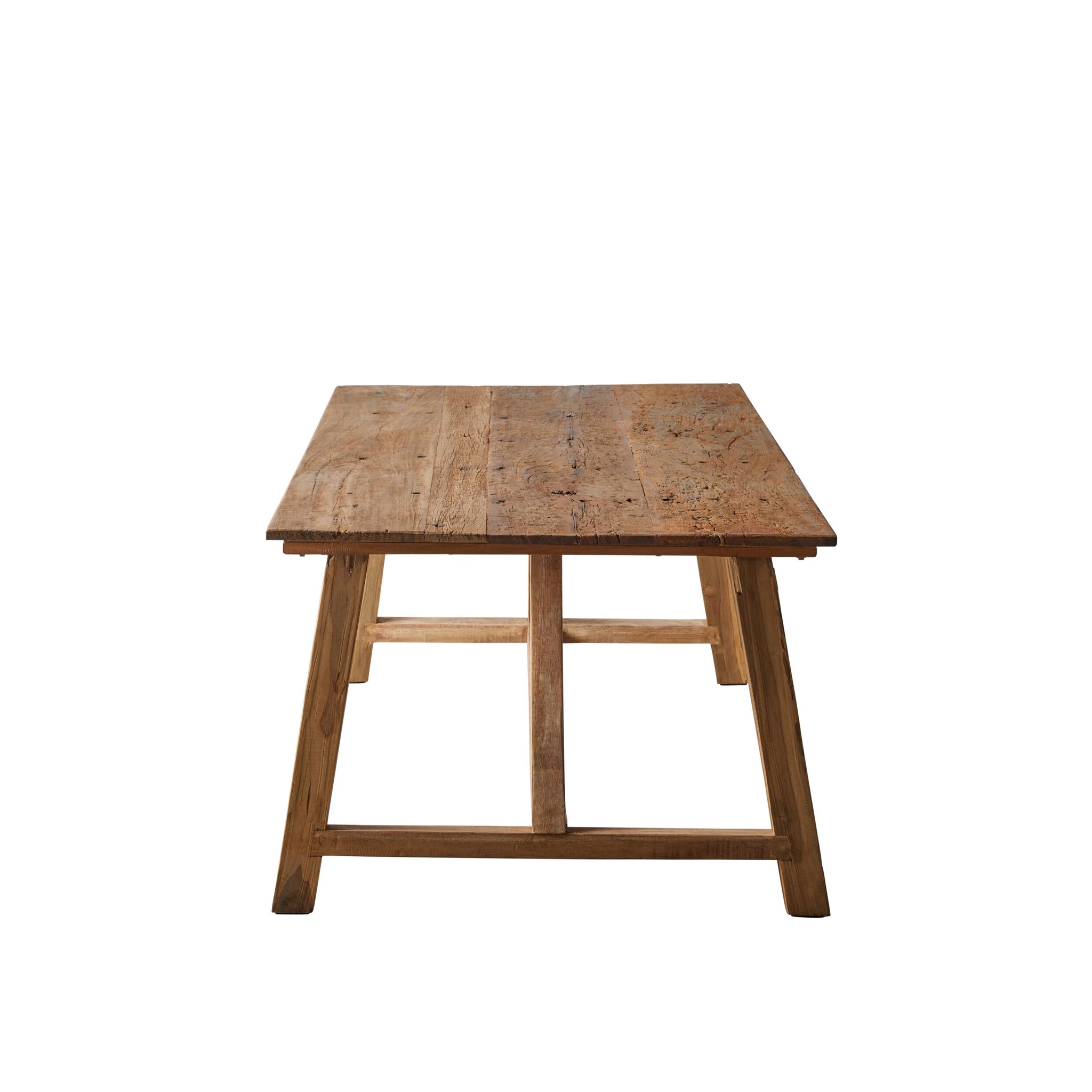 Another view of the long wooden table in a bright room with seating and decor