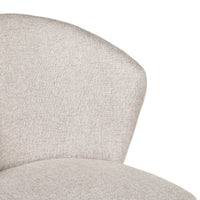 Close-up of the Cole Dining Chair Clay's curved, padded backrest and seat, upholstered in light beige textured fabric—ideal for a modern living style.