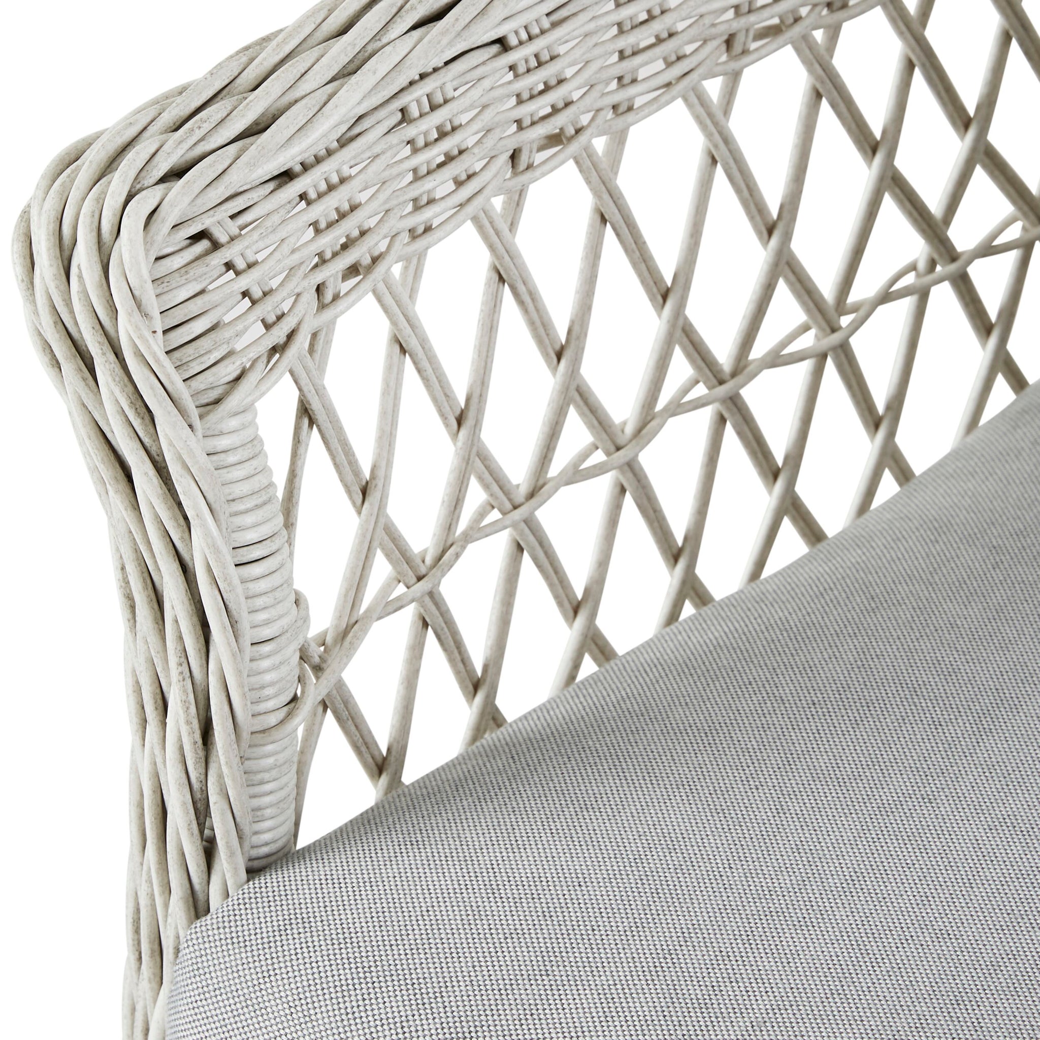 Close-up of the Catalina 4 Piece Sofa Set's wicker chair featuring a crisscross design and moisture-resistant cushions. The light gray seat enhances the all-weather wicker, ensuring durability and style for outdoor use.