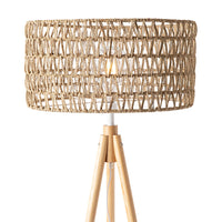The Lexi Seagrass Natural Tripod Floor Lamp (165x45cm) features a woven rattan shade and wooden legs, capturing the relaxed charm of coastal living. Shown against a white background.
