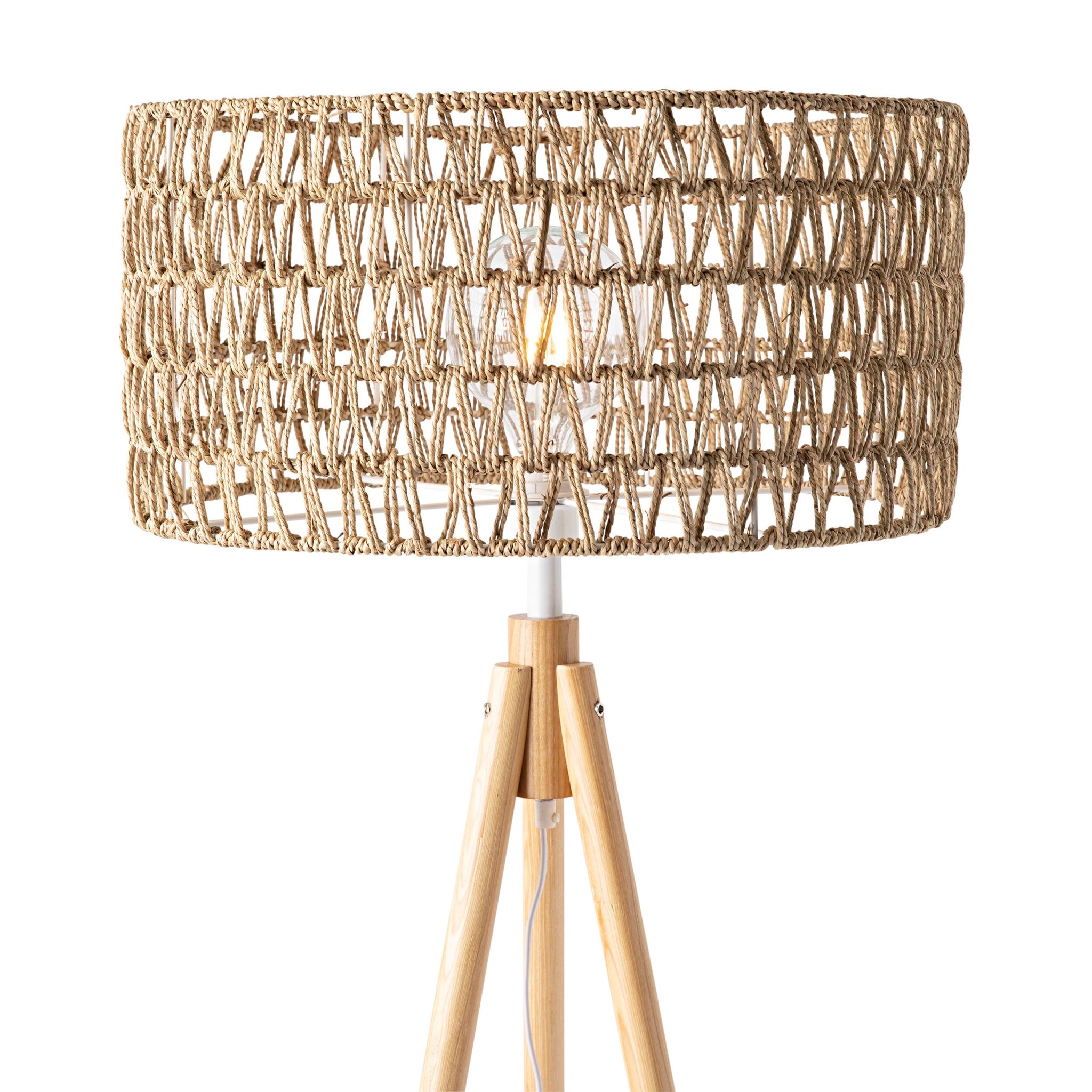 The Lexi Seagrass Natural Tripod Floor Lamp (165x45cm) features a woven rattan shade and wooden legs, capturing the relaxed charm of coastal living. Shown against a white background.