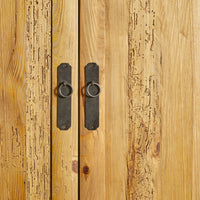 Close-up of the Kalise 2 Door Wardrobe, made from recycled pine with a lacquered finish. Black metal handles and ring pulls accentuate its rustic texture and visible wood grain patterns.