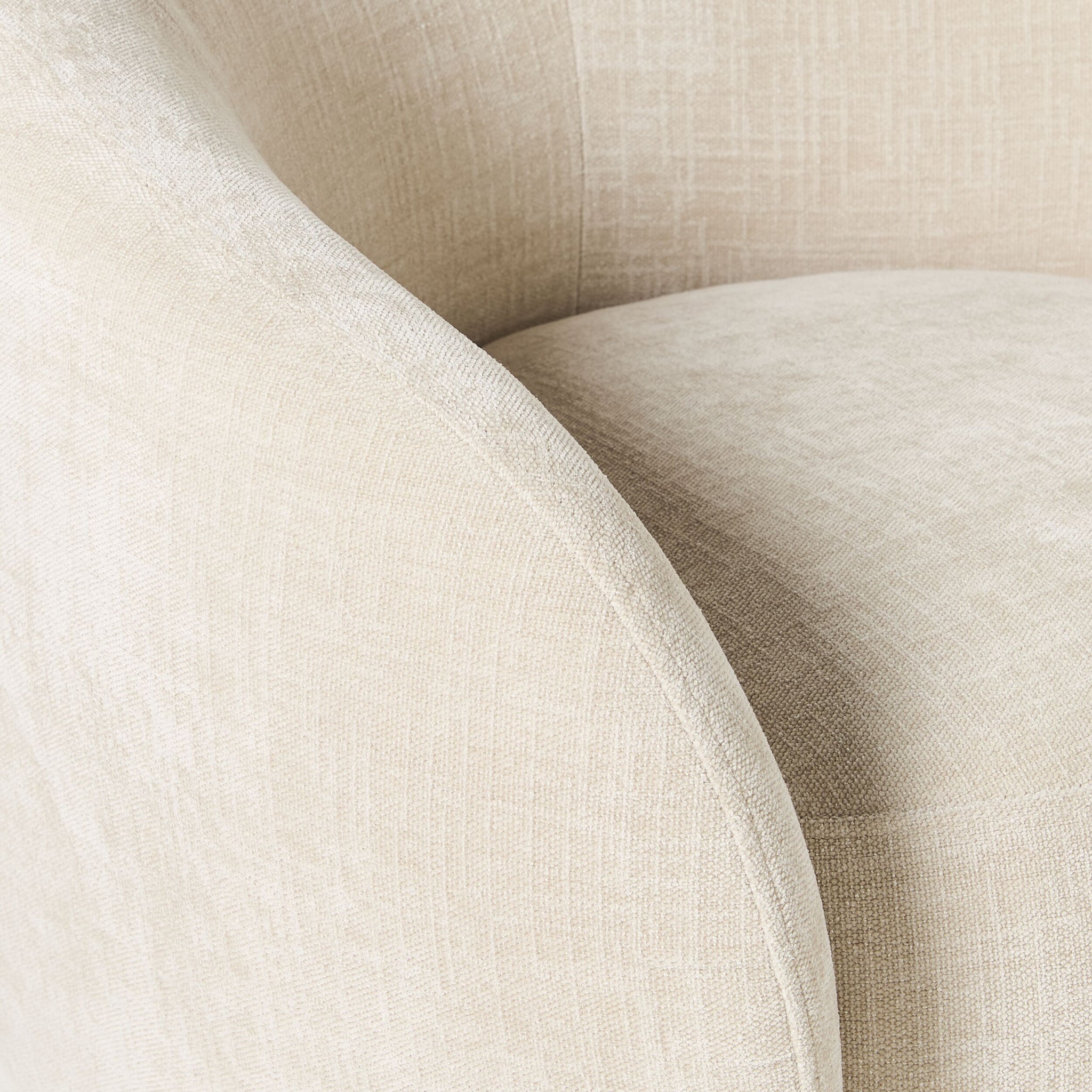 Close-up of the Alessa Swivel Armchair Oasis Dune, featuring beige chenille upholstery. Its textured fabric, curved armrest, and smooth surface add a stylish touch to any home decor.