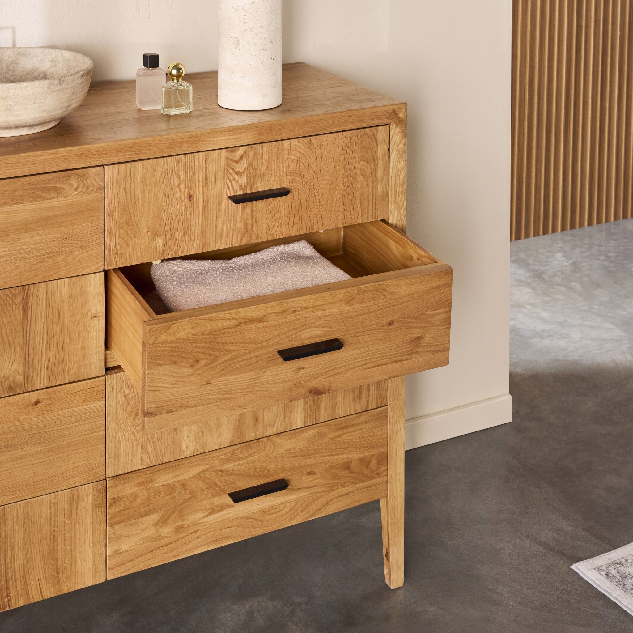 Close-up of one drawer pulled out showing joinery and wood grain on wooden dresser.