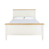 The Clover King Bed, inspired by Hamptons style, boasts a sophisticated white wooden frame accented with light wood trim. From the front view, it displays an elegant headboard and footboard, enhanced by two plush pillows atop the mattress. This piece exemplifies chic timber furniture design.