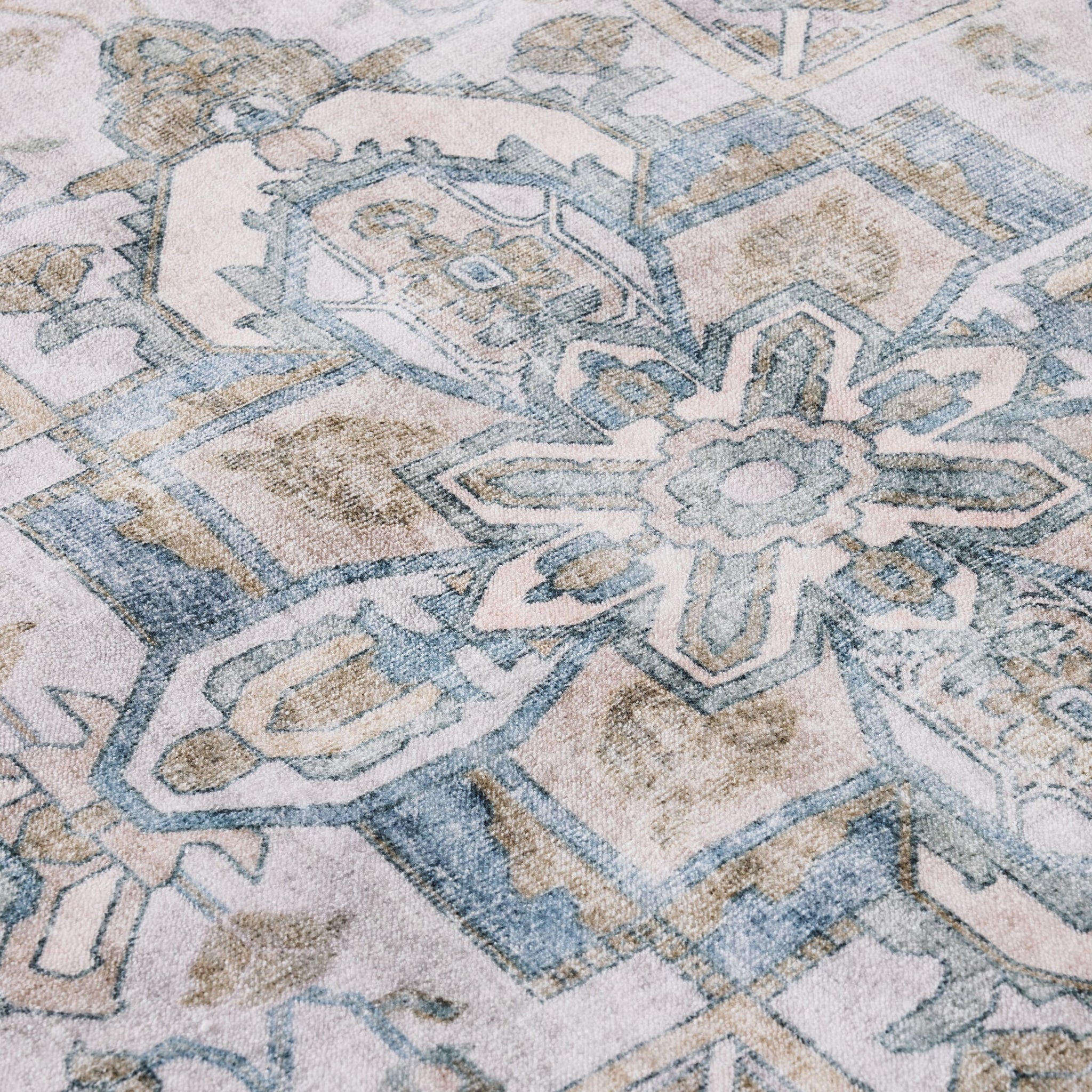 Close-up of the Manisa Washable Rug 240x300cm, showcasing Persian-inspired geometric and floral motifs in muted blue, beige, and cream tones, crafted from durable polyester.