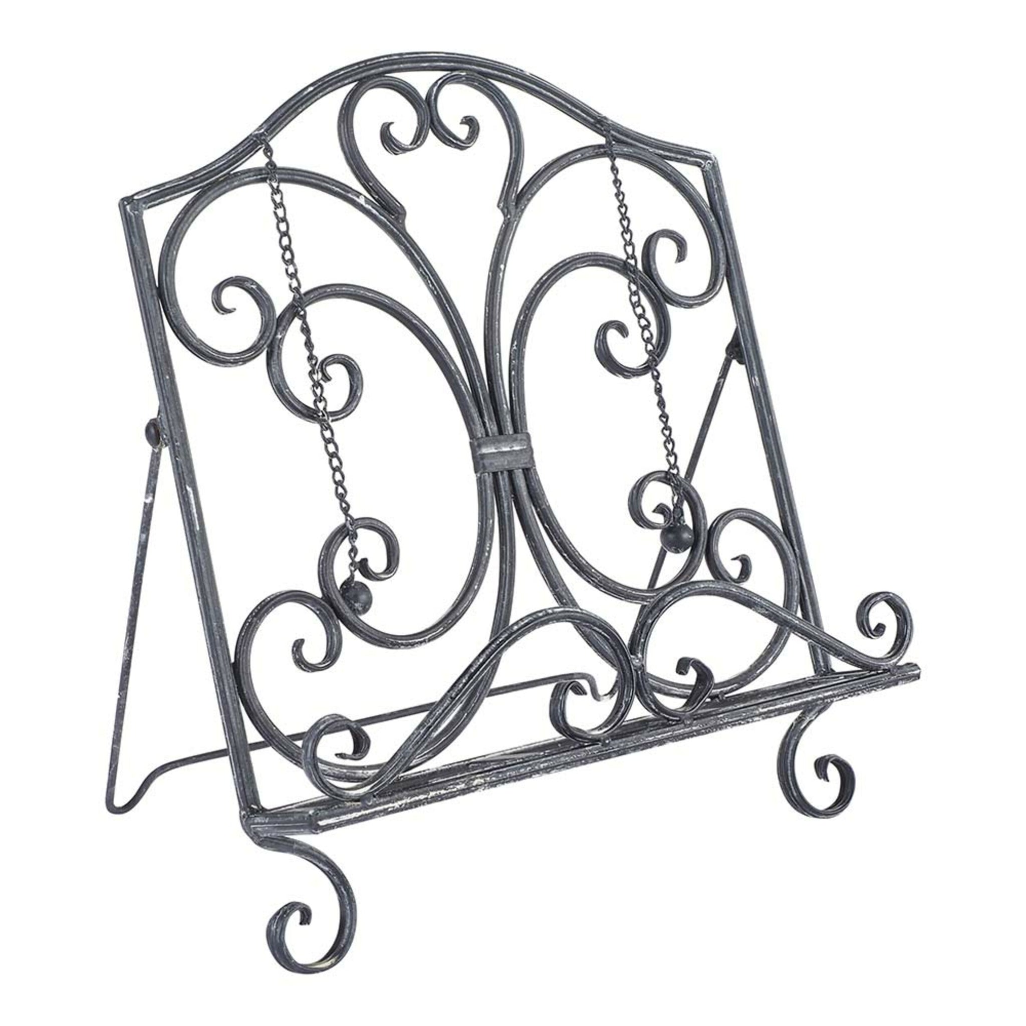 The Tissue/Book Stand 31x22x35cm boasts a decorative black metal design with an antique silver finish, featuring ornate scrollwork and an adjustable support chain for vintage elegance.