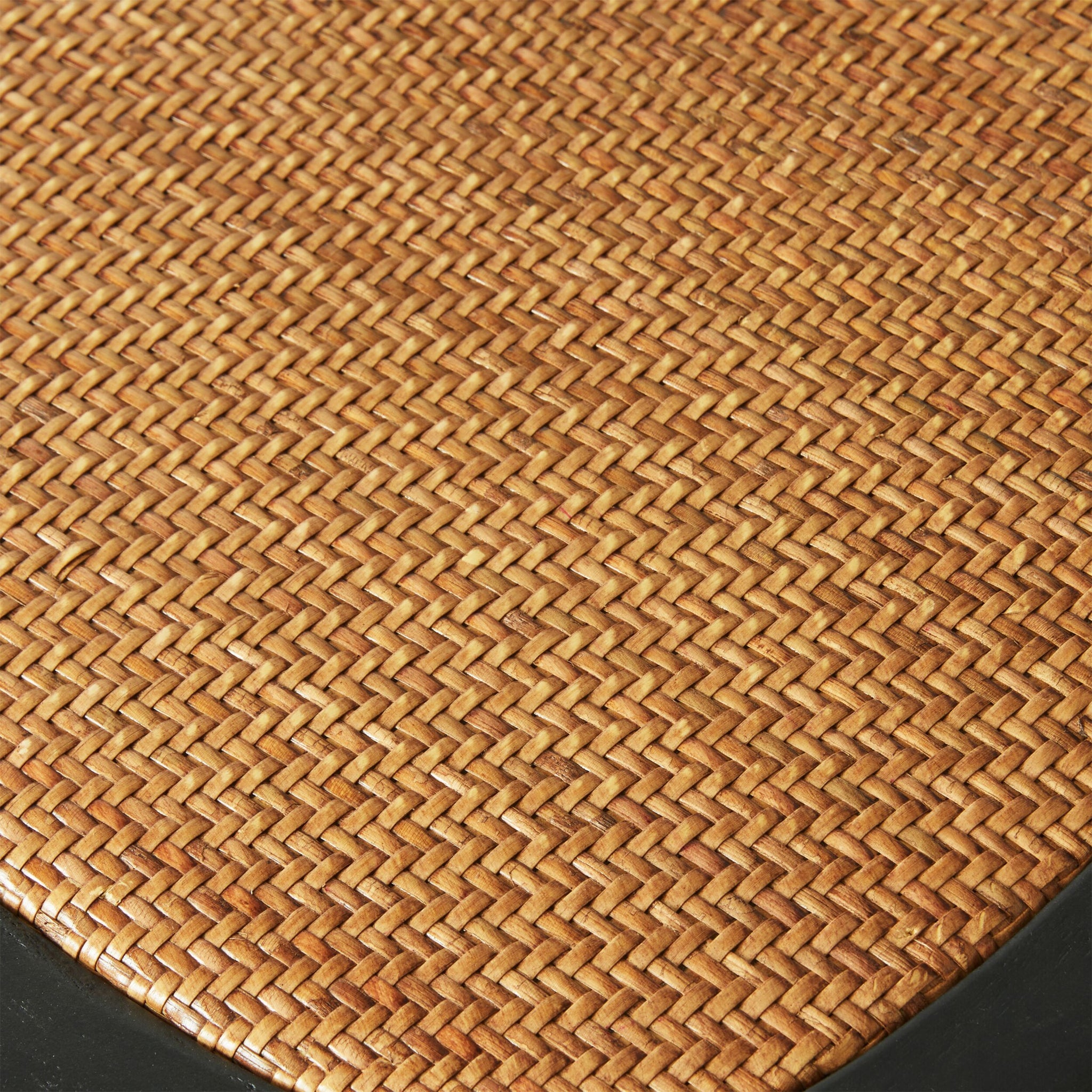 Close-up of a woven rattan texture with a simple braid pattern, featuring a black edge at the bottom. It exudes Parisian chic style reminiscent of the Provincial Cross Back Dining Stool Black.