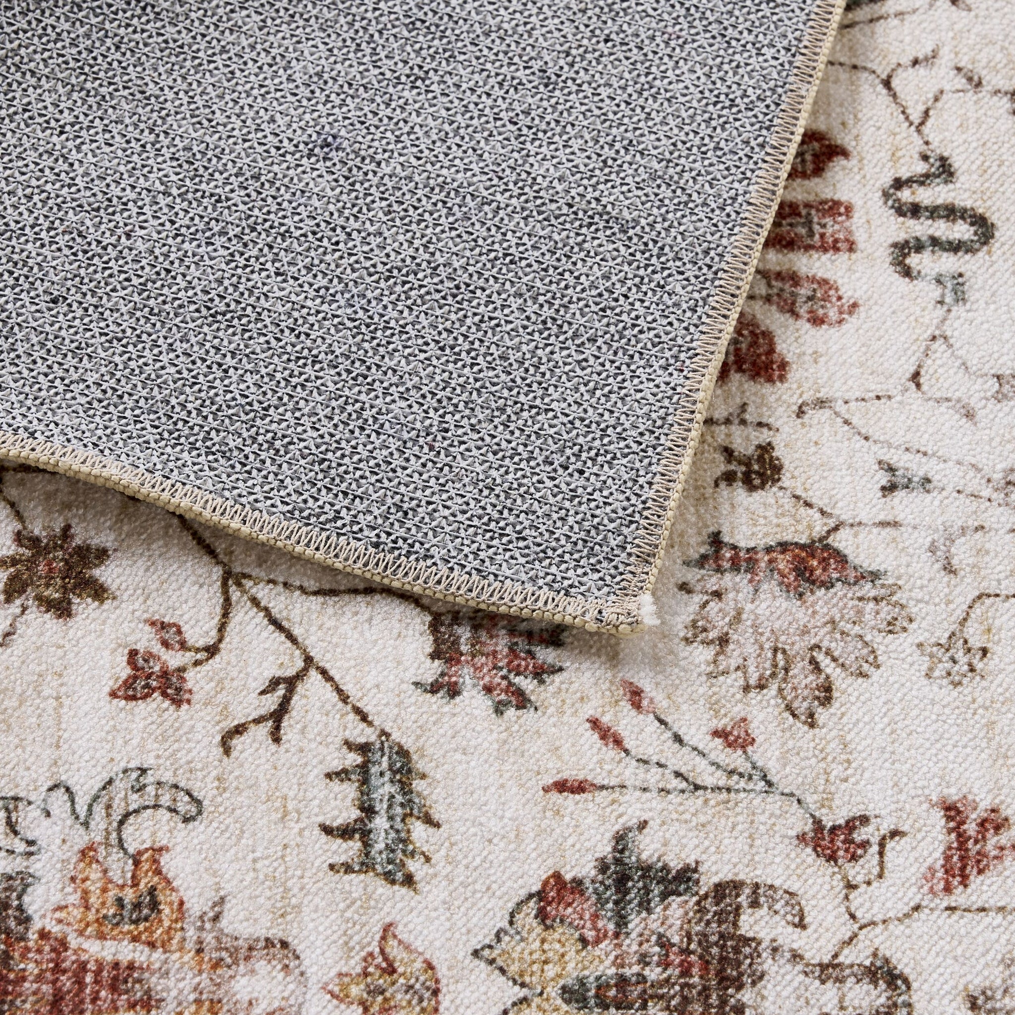 A corner of the Tarot Nouveau Washable Runner 80x200cm is folded over, showing its textured non-slip backing and floral pattern on the front.