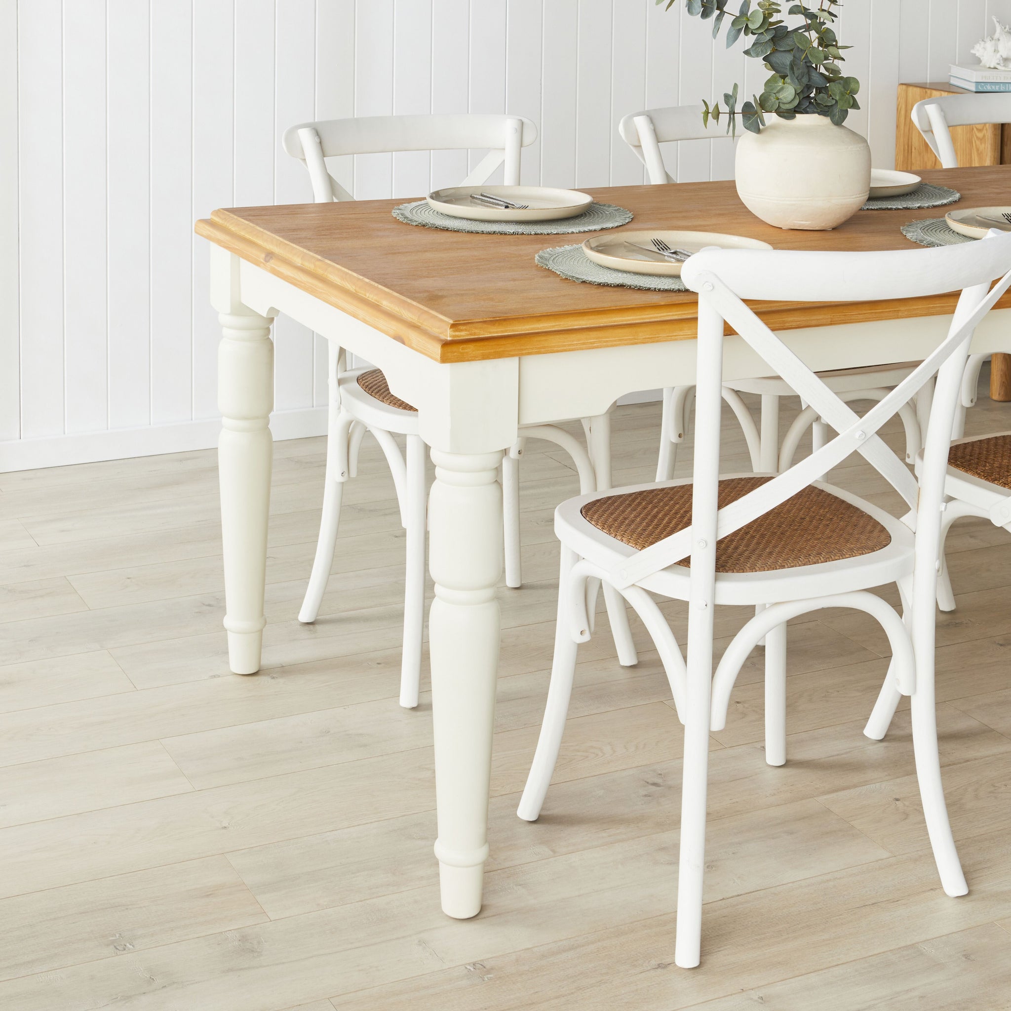 Room-wide view of the dining area showing the table and chairs against white panel walls and a sideboard.