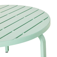 A detailed view of the Kace Outdoor Coffee Table in smoke green, a round piece crafted from galvanized steel with a slatted surface.