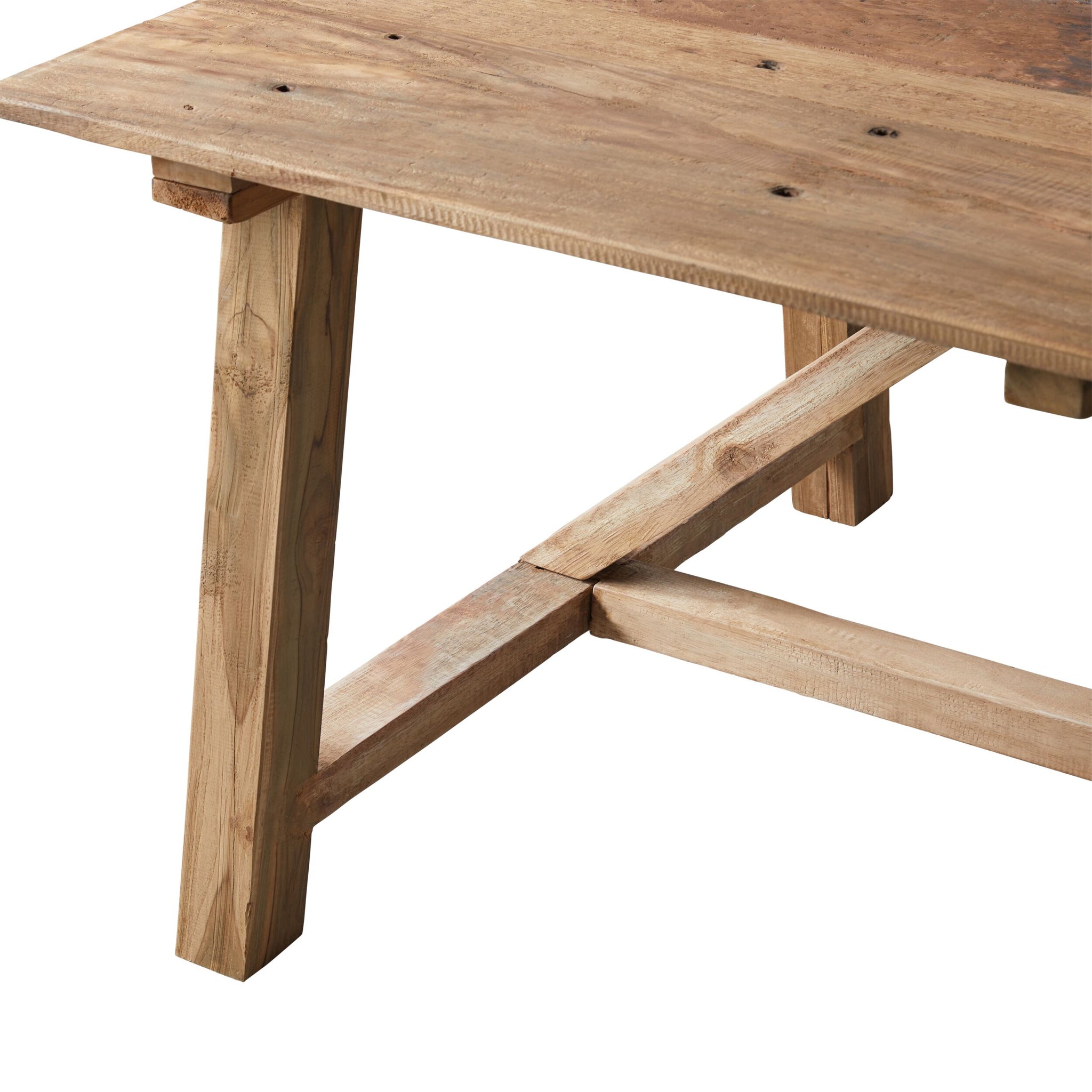 Rustic wooden dining table with thick top and trestle supports, close-up of leg and stretcher